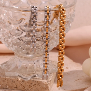 Three-color watch band style necklaces displayed on an embossed glass bowl edge