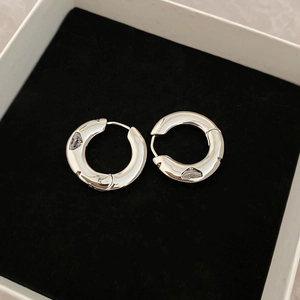 Detailed macro view of silver hoop earrings with polished finish in a black velvet jewelry box