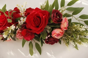 Detailed close-up of artificial rose floral arrangement with red and pink silk flowers
