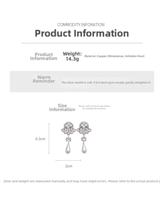 Detailed view of silver drop earrings with floral rhinestones and teardrop pearls