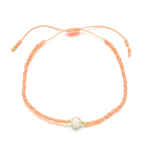 Detail of bohemian peach seed bead bracelet with natural freshwater pearl and gold beads