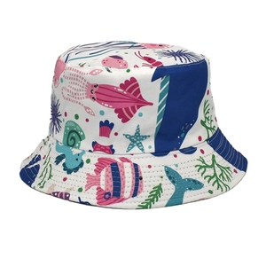 Dettaglio delle stampe marine con balene e pesci su un cappello a secchiello bianco da donna