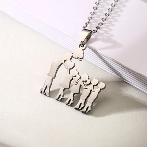 Macro shot of family of four silhouette pendant in silver stainless steel on white book