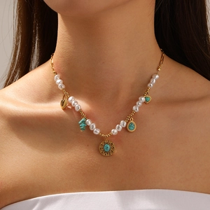 Detail of vintage gold pearl chain necklace with turquoise heart and drop pendants
