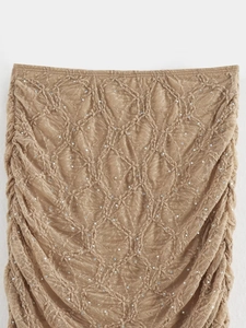 Détail du tissu en dentelle kaki avec sequins et plis latéraux sur cet ensemble chic