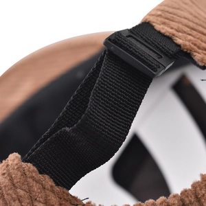 Detailed macro view of brown corduroy fabric and adjustable black strap on the cap
