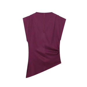 Detail view of burgundy sleeveless top featuring pleated shoulders and asymmetric hemline