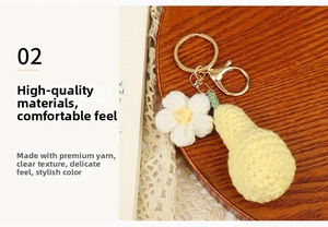Close-up of handmade crochet pear and flower keychain with golden metal clasp detail