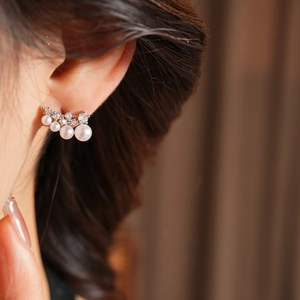 Close-up of 18k gold plated earrings featuring elegant white pearls and sparkling zircons