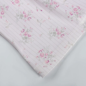 Détail du débardeur côtelé à fleurs montrant le motif floral rose et la couture de l'ourlet