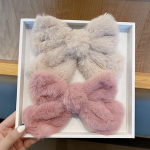 Pair of plush bow hair clips in beige and pink colors inside a white gift box