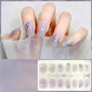 Macro detail of purple floral gel nail stickers with gold chain patterns and glitter