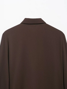 Detail view of the collar and shoulder seams on a dark brown textured fabric blazer