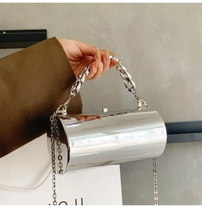 Mirror silver cylinder evening bag featuring chunky chain handle and crossbody strap detail
