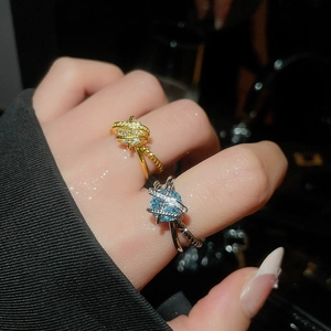 Detailed close-up of zircon-inlaid criss-cross rings in gold and silver luxury finish