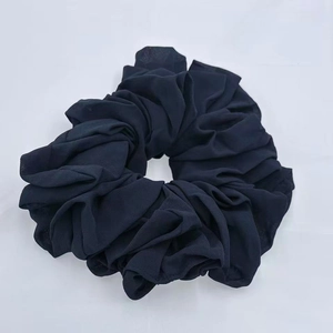 Detailed view of dark blue oversized chiffon scrunchie with soft ruffled fabric texture
