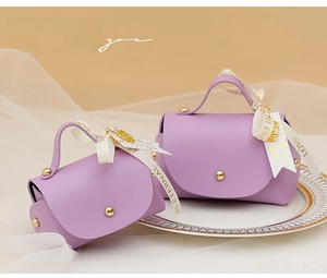 Detail of purple PU leather wedding favor bags with gold rivets and elegant ribbons