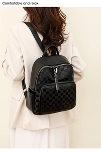Close-up of women's black checkerboard backpack showing leather texture and zipper detail