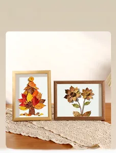 Detail of DIY dried leaf art in wooden 3D shadow box frame on a lace tablecloth