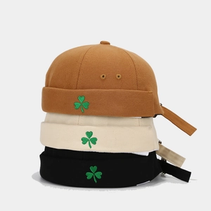 Three embroidered clover miki hats in brown, beige, and black canvas fabric styles