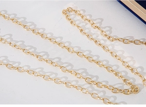 Detailaufnahme des goldfarbenen Metallkettenriemens für eine elegante Abendhandtasche