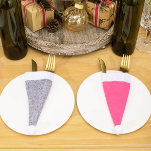 Detail von grauen und rosa Weihnachts-Besteckhaltern mit goldenen Gabeln auf festlichem Teller