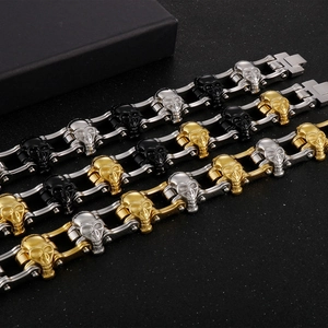 Macro detail of various skull biker bracelets with heavy metal chains in a dark setting