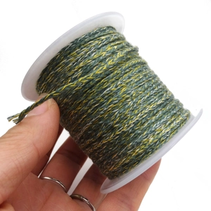 Close-up of green, yellow, and white twisted cotton cord roll for DIY crafts