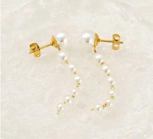 Detailed macro view of 18K gold stainless steel earrings with gradient pearl tassels