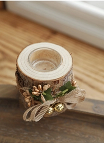 Macro shot of rustic wood candle holder with berries, pine cones and glass insert