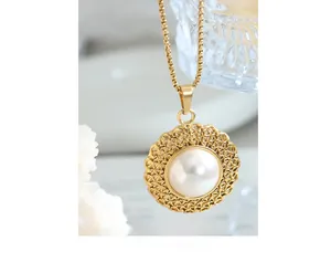 Detailed close-up of a vintage pearl pendant with golden lace frame and fine chain