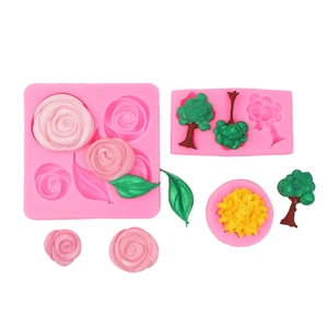 Detail of pink silicone fondant molds featuring rose, tree, and leaf shapes with textures