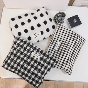 Vue détaillée de trousses à maquillage en tissu avec trois motifs noir et blanc élégants