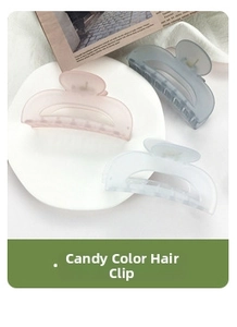 Close-up of three matte pastel claw clips on vintage paper and white fabric background