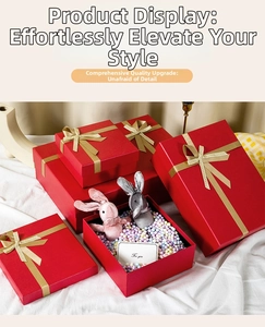 Detail of red gift boxes with gold ribbons, plush rabbits, and For You card