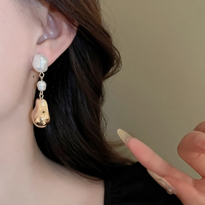 Boucles d'oreilles chic français en perles baroques et métal doré sur l'oreille