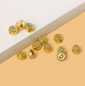 Macro shot of 5x10mm gold acrylic letter beads for DIY jewelry making and bracelets