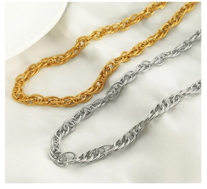 Macro shot of gold and silver interwoven double ring chains on white silk fabric