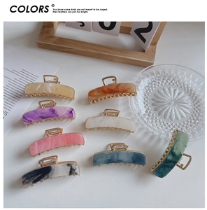 Flat lay of 7.5cm rectangle acetate claw clips in marble patterns and various colors