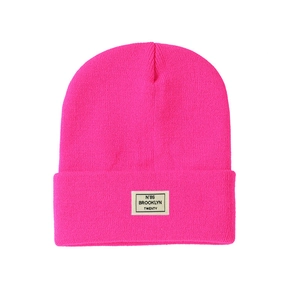 Detail of hot pink ribbed knit beanie featuring a stitched Brooklyn letter patch