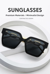 Detail view of square black sunglasses featuring unique gold chain link temple design