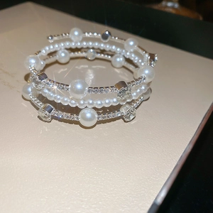Macro view of multi-layer layered bracelet with white pearls and micro-pave crystals