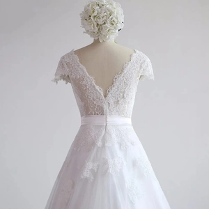 Close-up of deep V-neck lace bodice and delicate floral patterns on the white wedding gown