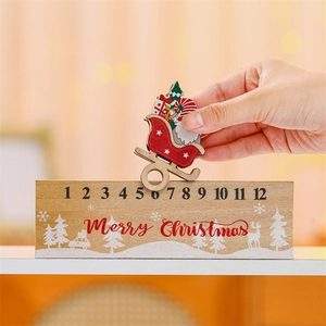 Detail showing a hand moving a Santa piece on a wooden Christmas countdown calendar base