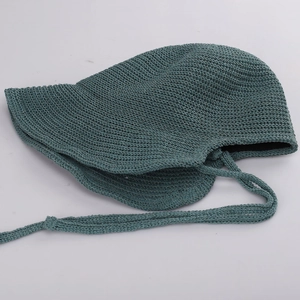 Detailed macro view of teal hand-knitted crochet sun hat with adjustable chin straps