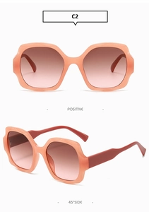 Detail view of wavy square pink frame sunglasses with gradient brown lenses