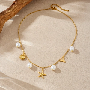 Gold stainless steel ocean necklace featuring pearls with starfish and shell pendants