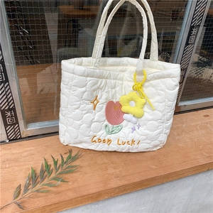 Quilted white canvas tote bag with floral embroidery and Good Luck text detail