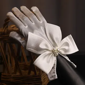 Short white satin bridal gloves with lace pearls and elegant bow for wedding photography