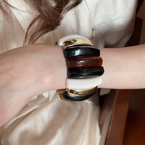 Detailed shot of multi-color acrylic rectangle bead bracelet with amber and metal accents